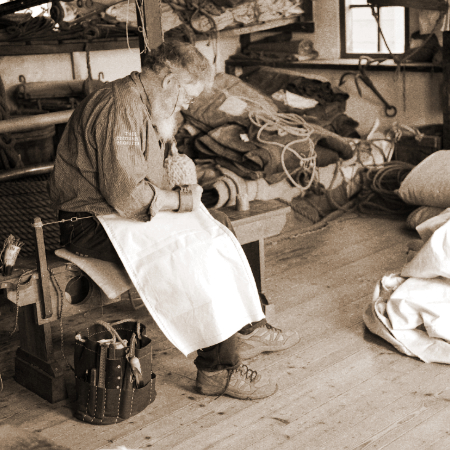 Sailmaker creating a new sail by hand the old fashioned way.